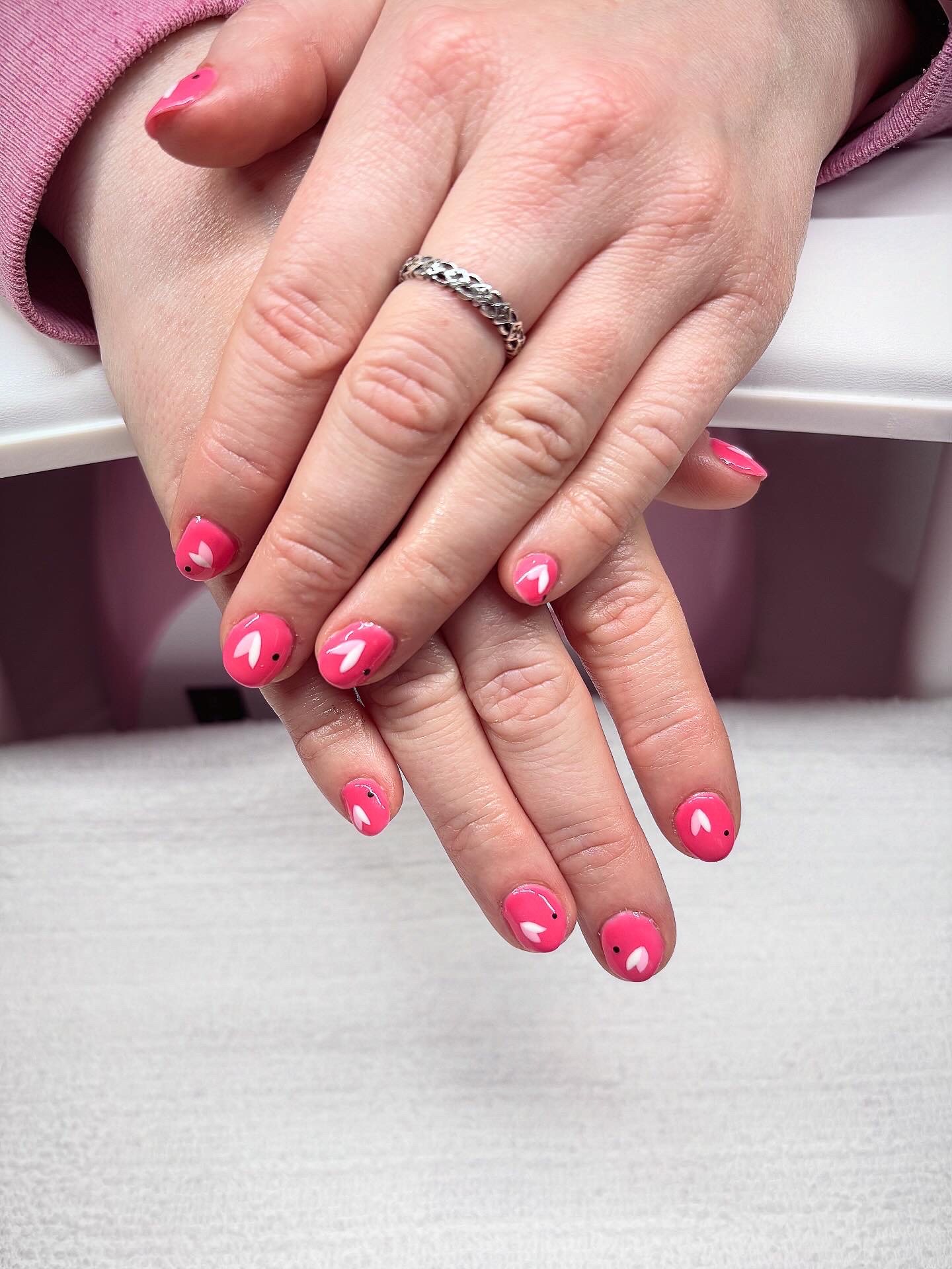 Bright pink nails with little white hearts