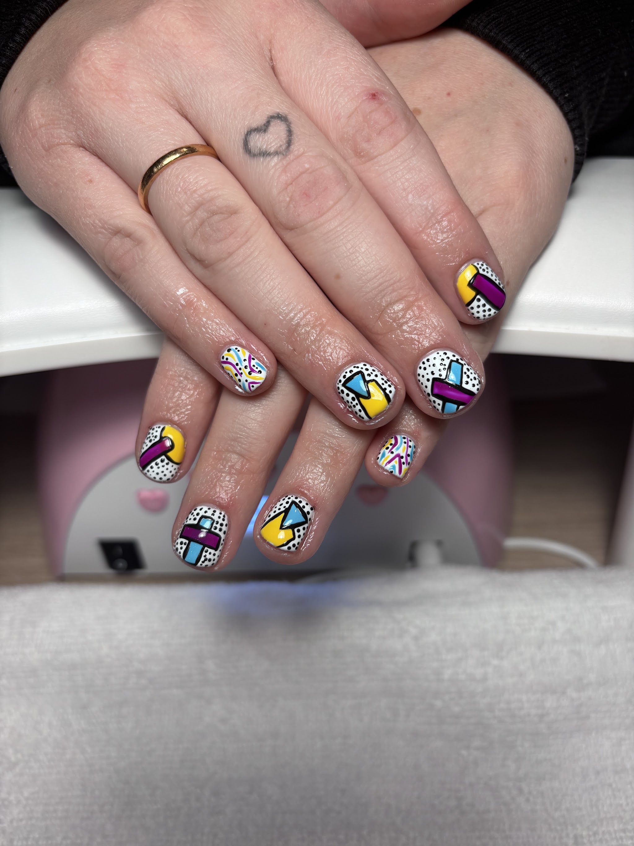 Bold geometric nail art in yellow, pink and blue