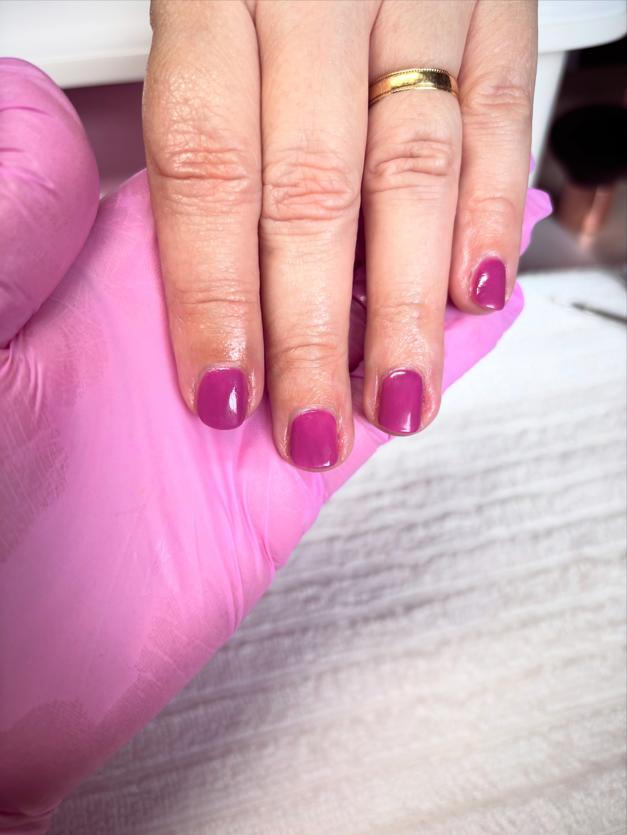 Berry gel nails on a pink towel